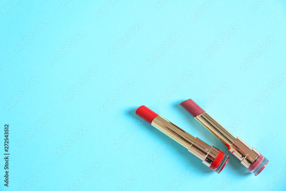Flat lay composition with different stylish lipsticks on color background, space for text Flat lay composition with different stylish lipsticks on color background, space for text