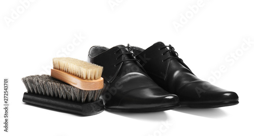 Stylish men's shoes and cleaning brushes on white background