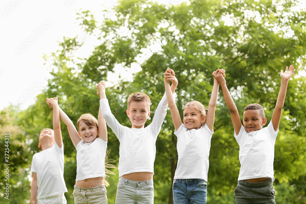 Group of children holding hands up in park. Volunteer project Group of children holding hands up in park. Volunteer project