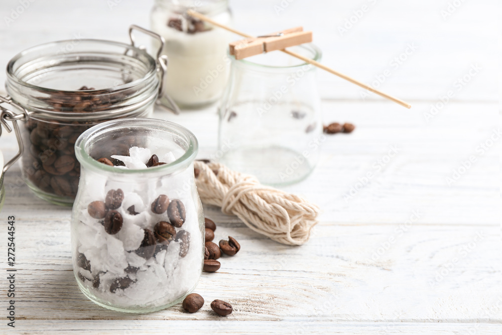 Glass jar, wax and coffee beans for making handmade candle on wooden table. Space for text Glass jar, wax and coffee beans for making handmade candle on wooden table. Space for text