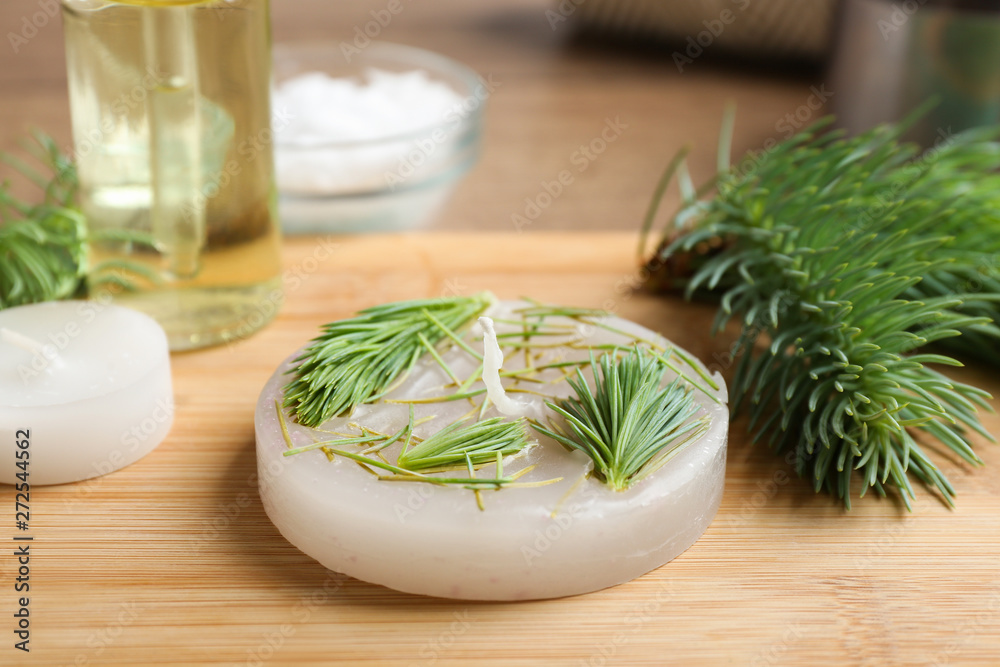 Board with handmade candle and ingredients on table