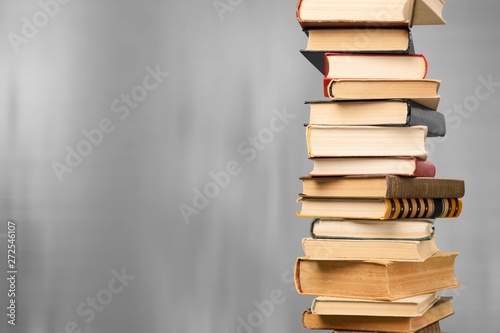 Collection of old books vertical stack on beige background