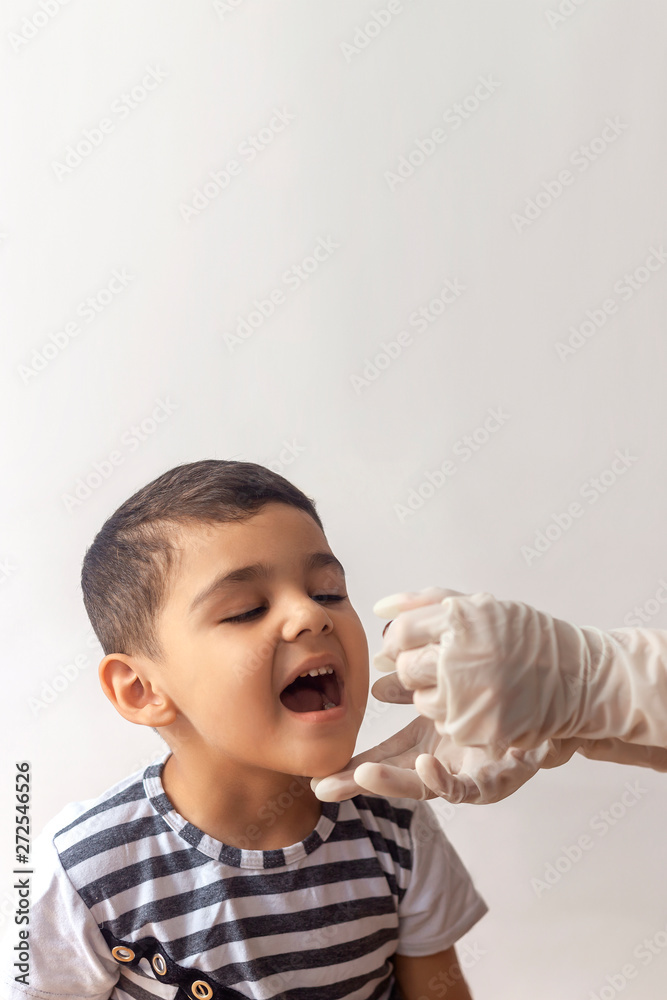 Child immunization with little drop in clinic. Doctor providing immunization vaccines. Little boy gets medicine from a little bottle Child immunization with little drop in clinic. Doctor providing immunization vaccines. Little boy gets medicine from a little bottle
