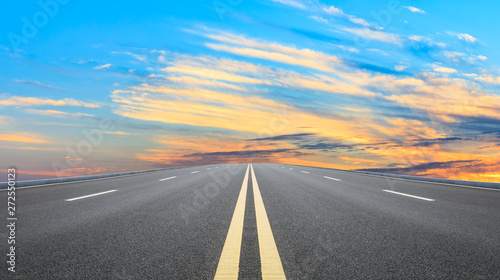 Straight asphalt road and sunset sky