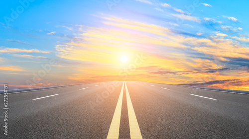 Straight asphalt road and sunset sky