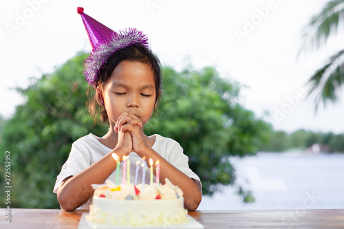 Canvas Print Cute asian child girls make folded hand to wish the good things for her birthday