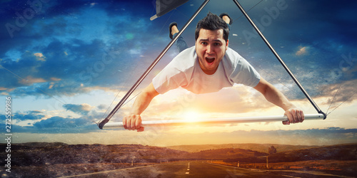 Foto Young man flying on hang glider. Mixed media