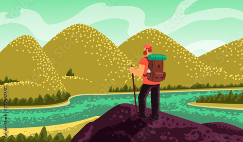 Man hiker, stands on top and looks at the mountains and the river