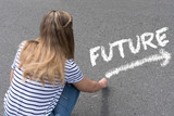 EIne junge Frau schreibt mit der Kreide das Wort Zukunft auf die Straße