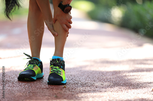 Female runner suffering with pain on sports running injury photo