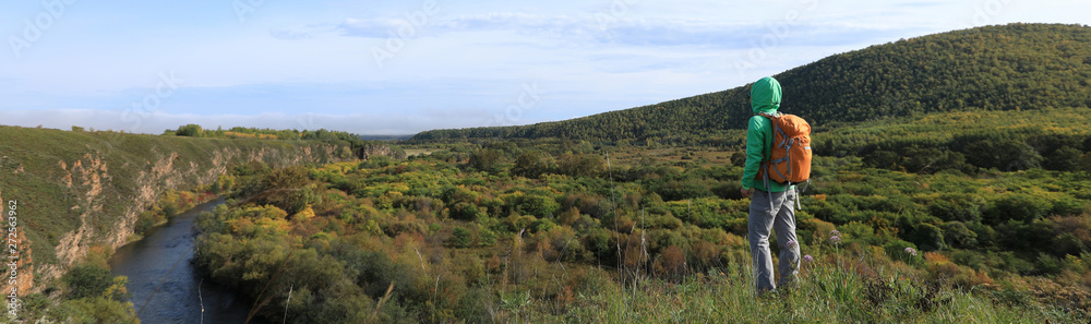 woman hiker with backpack hiking in the autumn nature