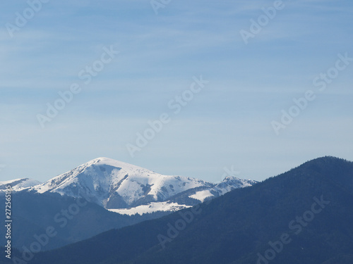 Morning landscape with mountains and blue sky. Evening sunset on the horizon of hills with white snow and cloud