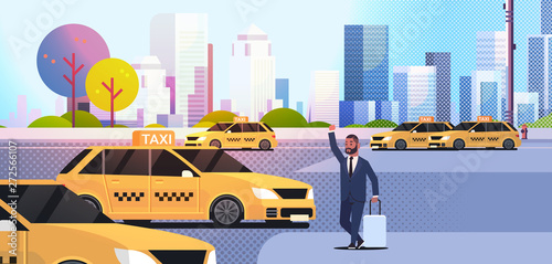 businessman catching taxi on street african amerian business man with luggage stopping yellow cab city transportation service concept cityscape background full length flat horizontal
