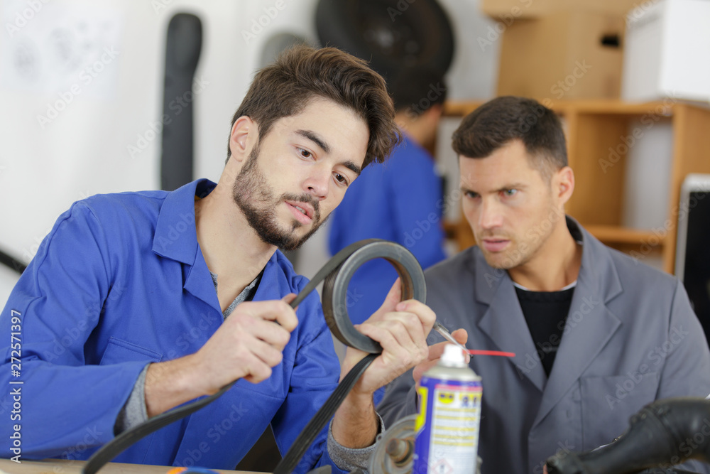 Fototapeta premium apprentice mechanic being assessed while working