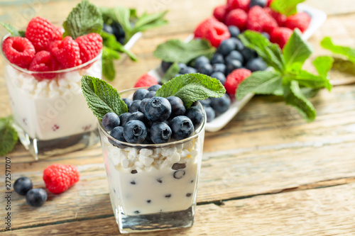 Cottage cheese with cream, raspberry and blueberry garnished with fresh mint.