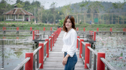 The girl standing on the red bridge