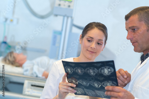 medical staff looking at scan results patient in background