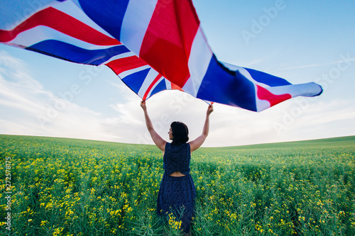 Woman holding the British flag outdoors photo