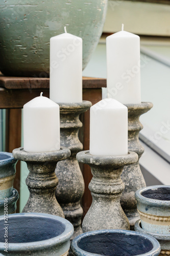 Handmade ceramic candle sticks with big candles in decor shop.