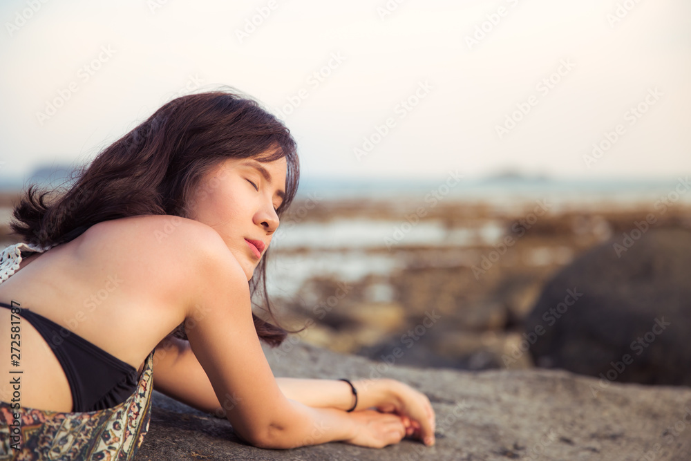 Portrait of Beautiful Asian woman smiling relaxing on summer beach.