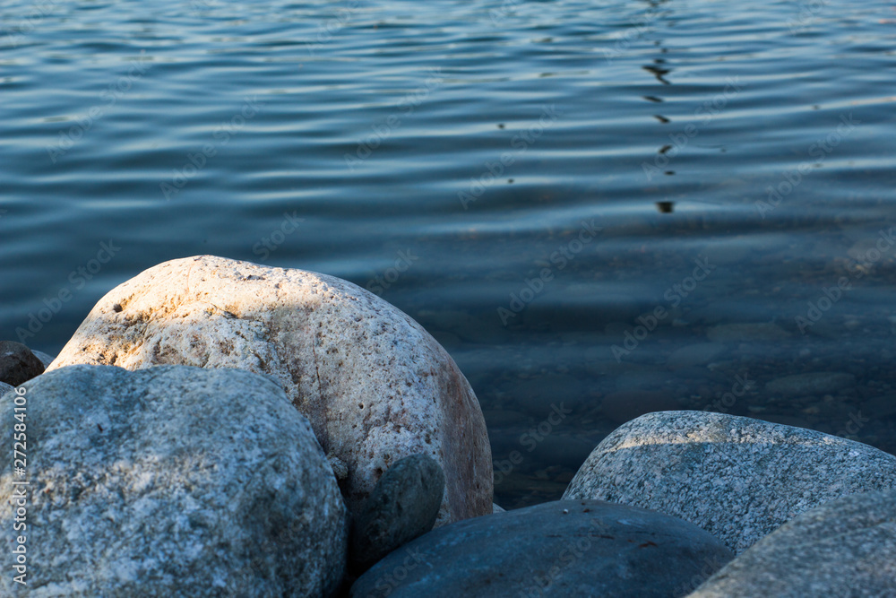 Rocks in water, wet background, summer seashore