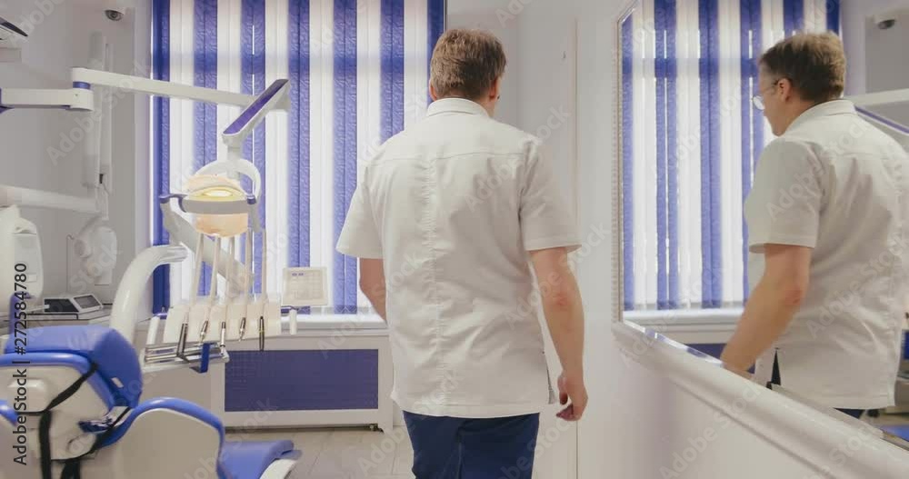 Caucasian mature dentist entering his empty office in the morning preparing for work Caucasian mature dentist entering his empty office in the morning preparing for work