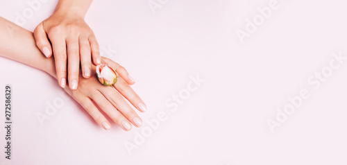 Stylish trendy female manicure. Woman's Hands holding rose flower on pink background. Top view, flat lay