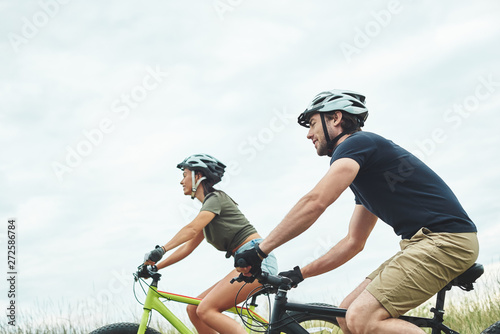 Young couple are cycling on fatbikes and in helmets. Cropped photo