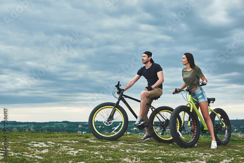 Afternoon sunset with mountainbike couple. Side view