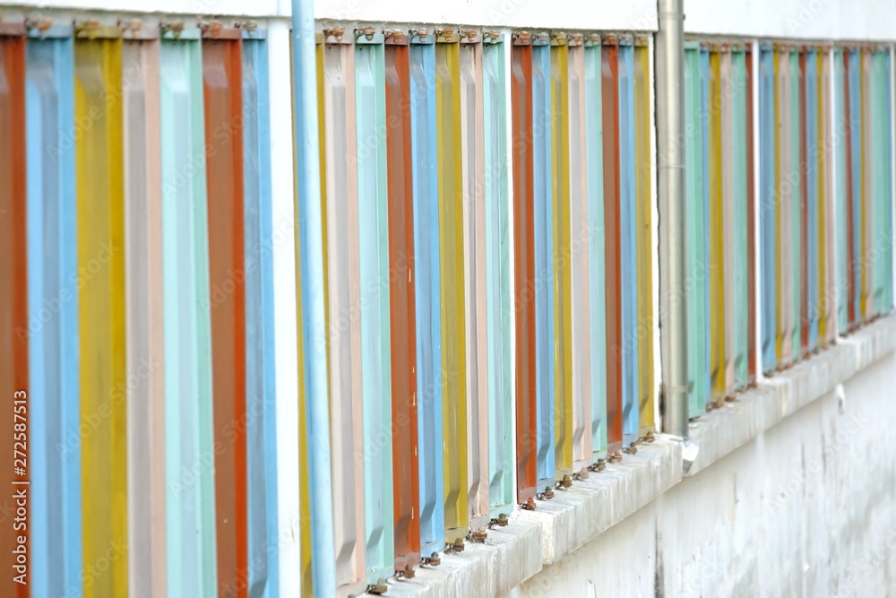 A row of multicolored windows on the old building wall A row of multicolored windows on the old building wall