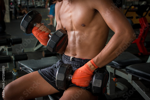 Thai boxer sport man doing exercise with dumbbells.
