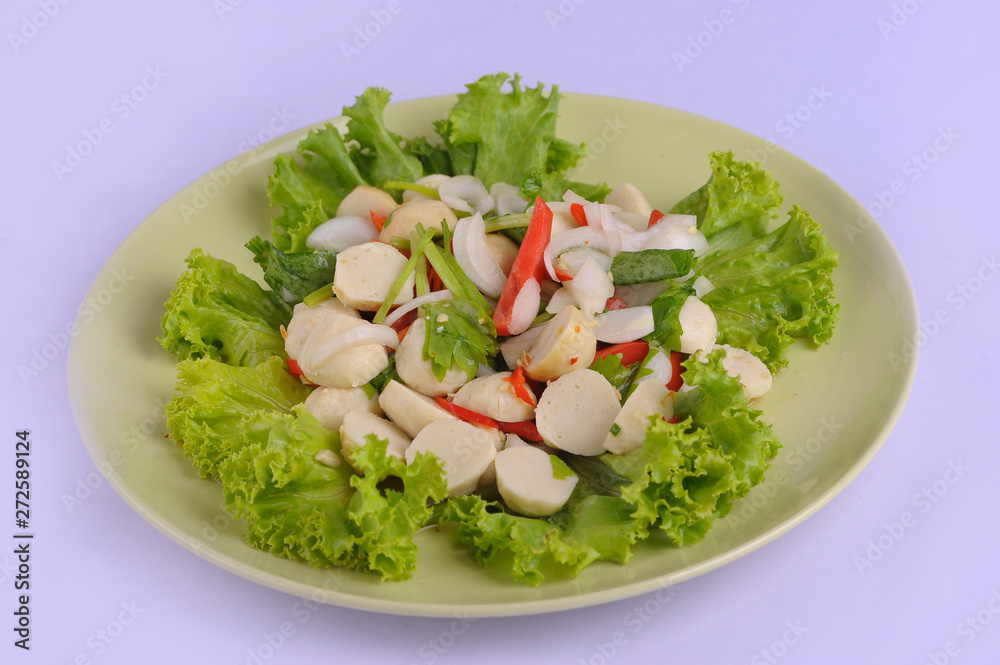Spicy salad fish ball in a white dish with chopsticks on white background Spicy salad fish ball in a white dish with chopsticks on white background