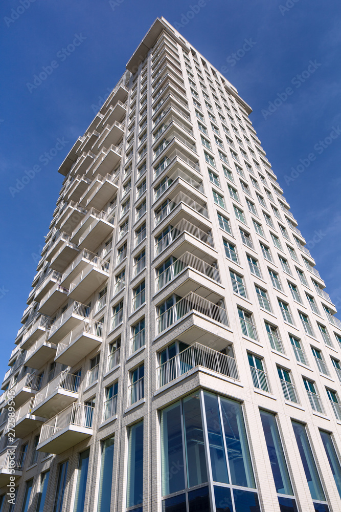 Contemporary white residential tower against a blue sky