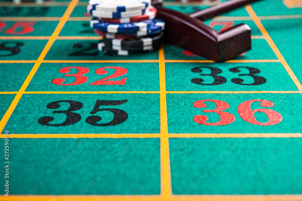 Roulette green table close up, numbers and poker casino chips Roulette green table close up, numbers and poker casino chips
