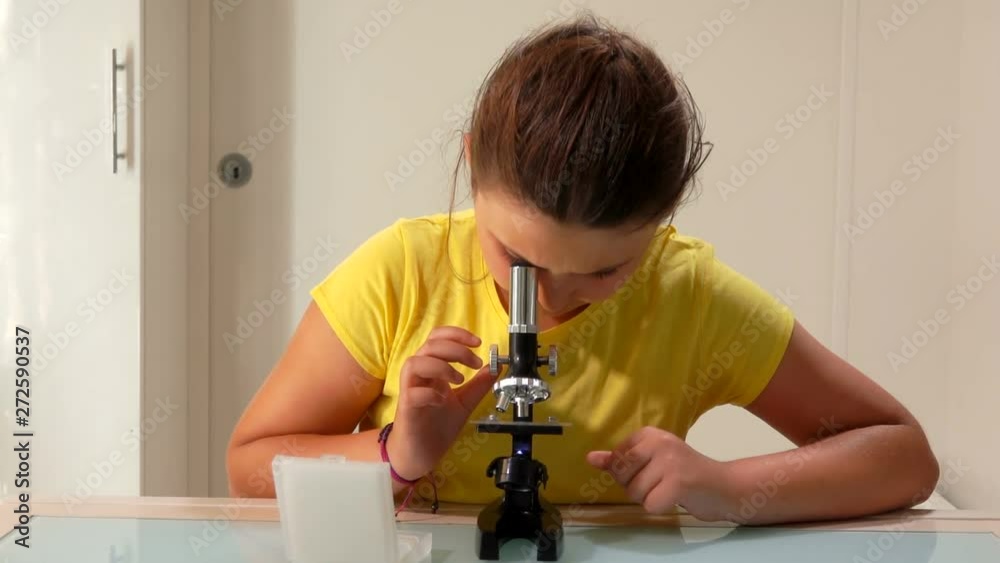 Serious girl changes a sample in a microscope. Serious girl changes a sample in a microscope.