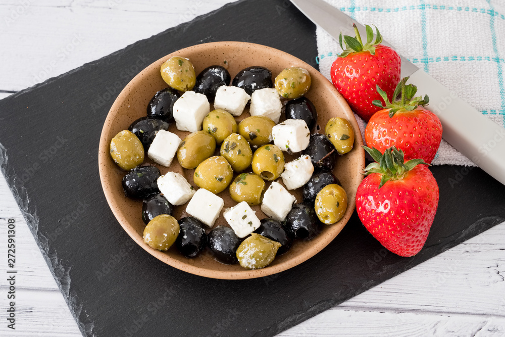 Feta Cheese with Green and Black Olives and Strawberries served in a Bowl Feta Cheese with Green and Black Olives and Strawberries served in a Bowl