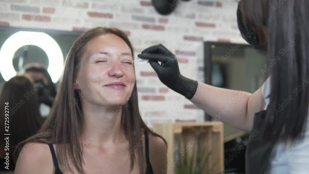A young woman came to the beauty salon for coloring and eyebrow correction. Beautician removes eyebrows and cleans hair and skin before the procedure. A young woman came to the beauty salon for coloring and eyebrow correction. Beautician removes eyebrows and cleans hair and skin before the procedure.