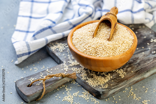 Bowl with sesame seeds and wooden scoop.
