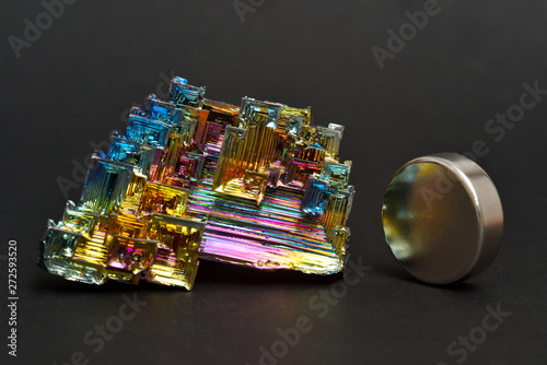 Bismuth crystals and a neodymium magnet on a dark background. This is the most strongly diamagnetic element and also the heaviest that is not radioactive.