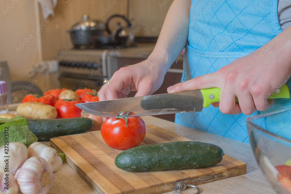 woman cooking healthy meal in the kitchen. Cooking healthy food at home. Woman in kitchen preparing vegetables. Chef cuts the vegetables into a meal woman cooking healthy meal in the kitchen. Cooking healthy food at home. Woman in kitchen preparing vegetables. Chef cuts the vegetables into a meal