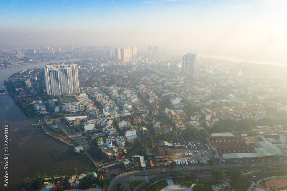 Obraz premium Top View of Building in a City - Aerial view Skyscrapers flying by drone of Ho Chi Mi City with development buildings, transportation, energy power infrastructure. include Landmark 81 and blue sky ,