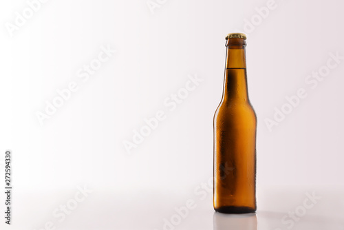 Beer bottle filled and closed on glass table white background.