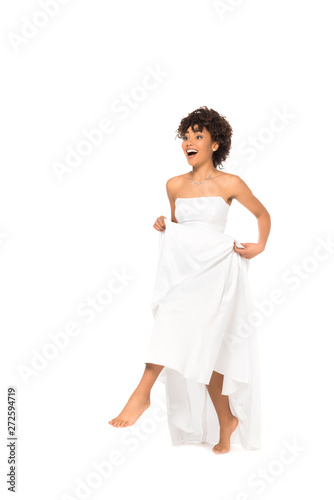 happy african american bride touching wedding dress and walking isolated on white © LIGHTFIELD STUDIOS