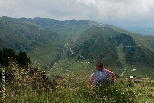 Young Man sitting alone outdoor with mountains on background