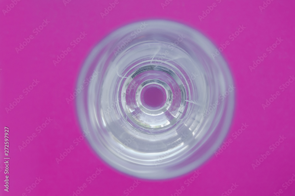 glass wineglass with reflections on pink vivid background. view from above. abstraction glass wineglass with reflections on pink vivid background. view from above. abstraction