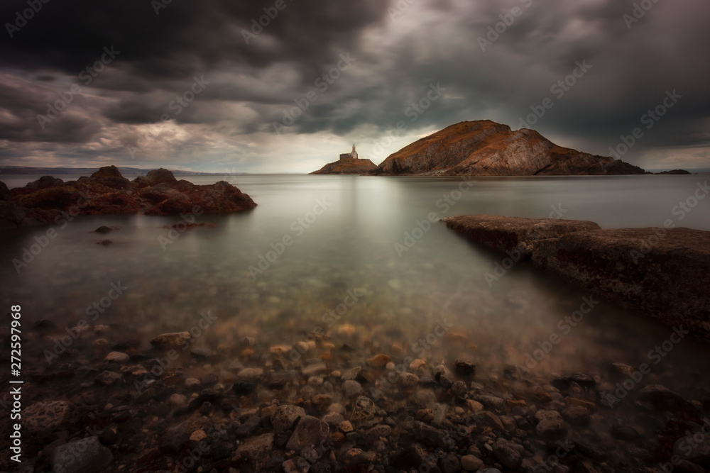Rough weather over Mumbles lighthouse Dramatic storm clouds over Swansea Bay and Mumbles lighthouse in Swansea, South Wales UK Rough weather over Mumbles lighthouse Dramatic storm clouds over Swansea Bay and Mumbles lighthouse in Swansea, South Wales UK