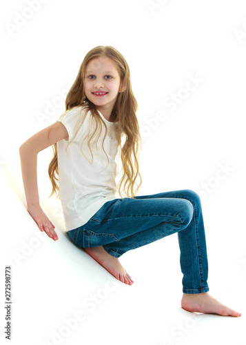 A little girl is photographed in the studio on a cyclorame.
