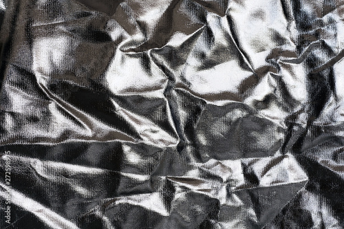 Textured silver foil background with shiny crumpled surface.