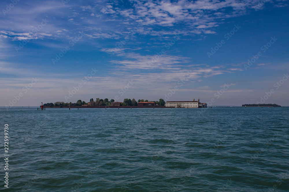 View of the islands, Venice, Italy. Lagoon on a bright summer day. Seascape with two islands, trees and houses on them.