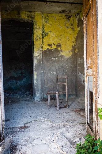 Old chair abandoned in a empty room. A glimpse of ghost town Alianello. Matera province  Italy